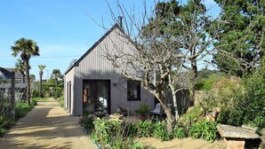 A single-story house with a gravel driveway leading to a wooden door.