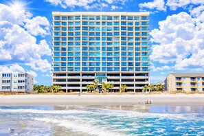 A multi-story hotel with a large number of windows, located near a beach with clear skies. - North Shore Villas 801 (North Myrtle Beach)
