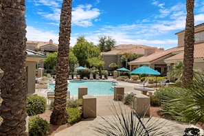 A pool area with lounge chairs and umbrellas, surrounded by palm trees and a clear sky. - Poolside Resort Style Awesomeness (Phoenix)