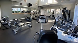 A gym with exercise equipment, a mirror, and large windows. - Poolside Resort Style Awesomeness (Phoenix)