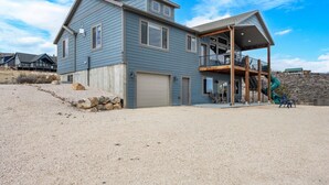 Ein zweistöckiges Haus mit Garage, Balkon und Rutsche.