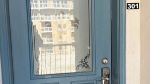 Uma porta azul com o número '301' na parede ao lado.