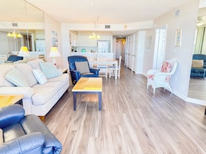 A spacious living room with a sofa, a coffee table, and a dining area with chairs. - North Shore Villas 502 (North Myrtle Beach)