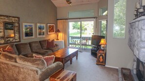 Ein gemütliches Wohnzimmer mit Kamin, einer Couch, einem Couchtisch und einem Fernseher.
