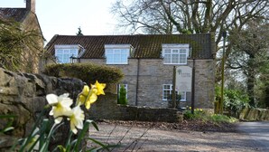 A stone building with a traditional design, featuring multiple windows and a signboard. - The Coachhouse (Scarborough)