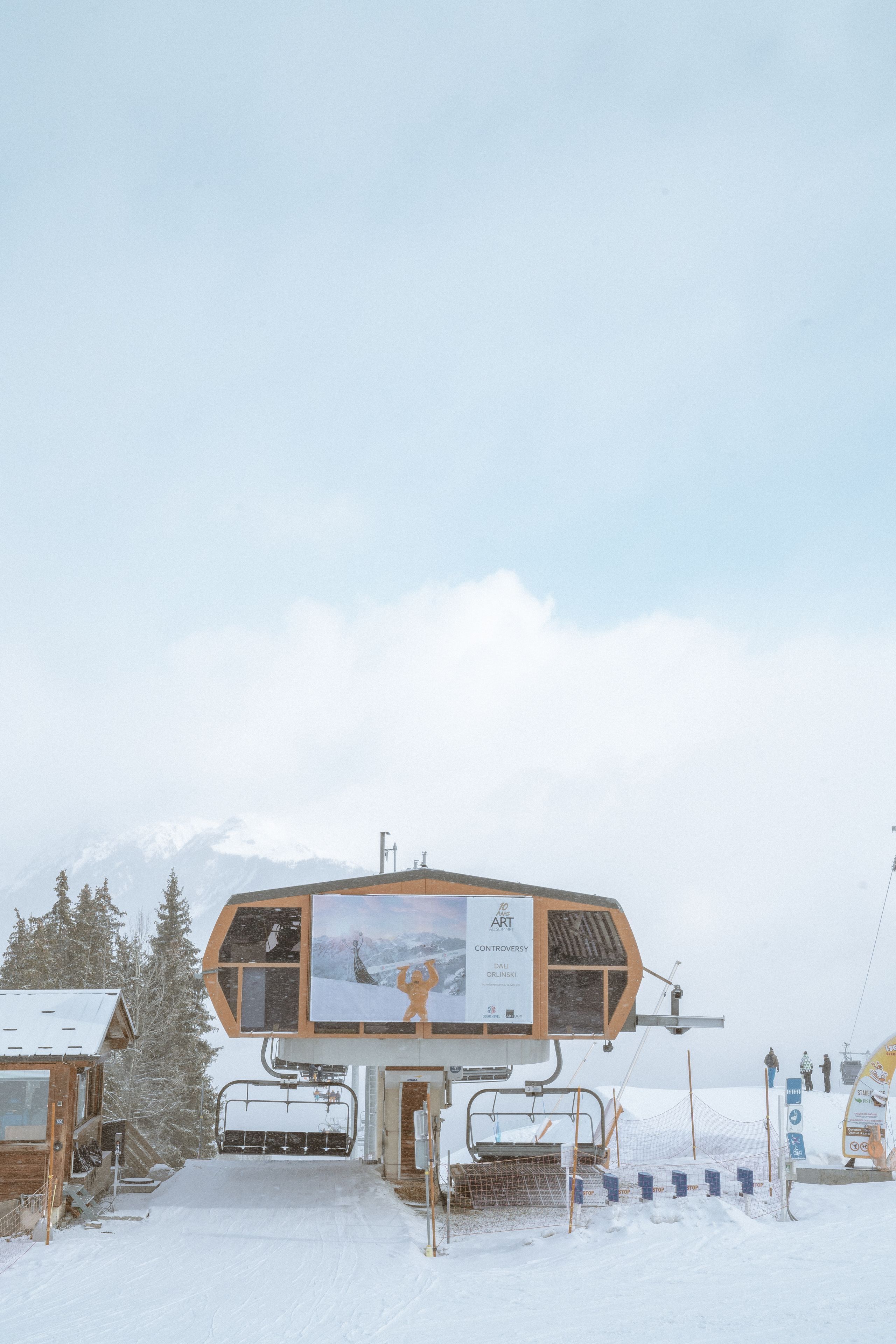 A ski lift station with a wooden building and a snow-covered landscape.