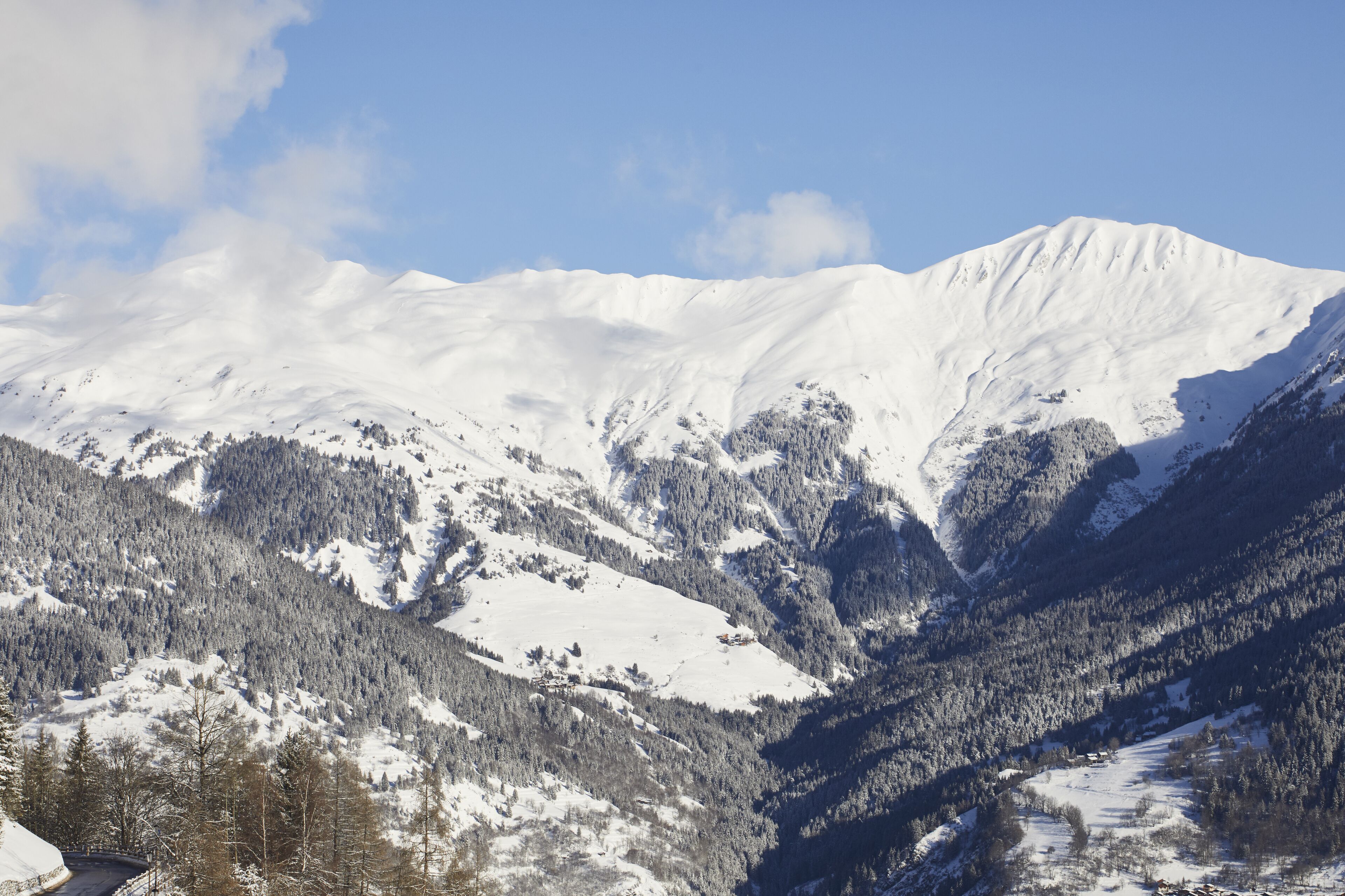 Un paisaje montañoso cubierto de nieve con cielo despejado.