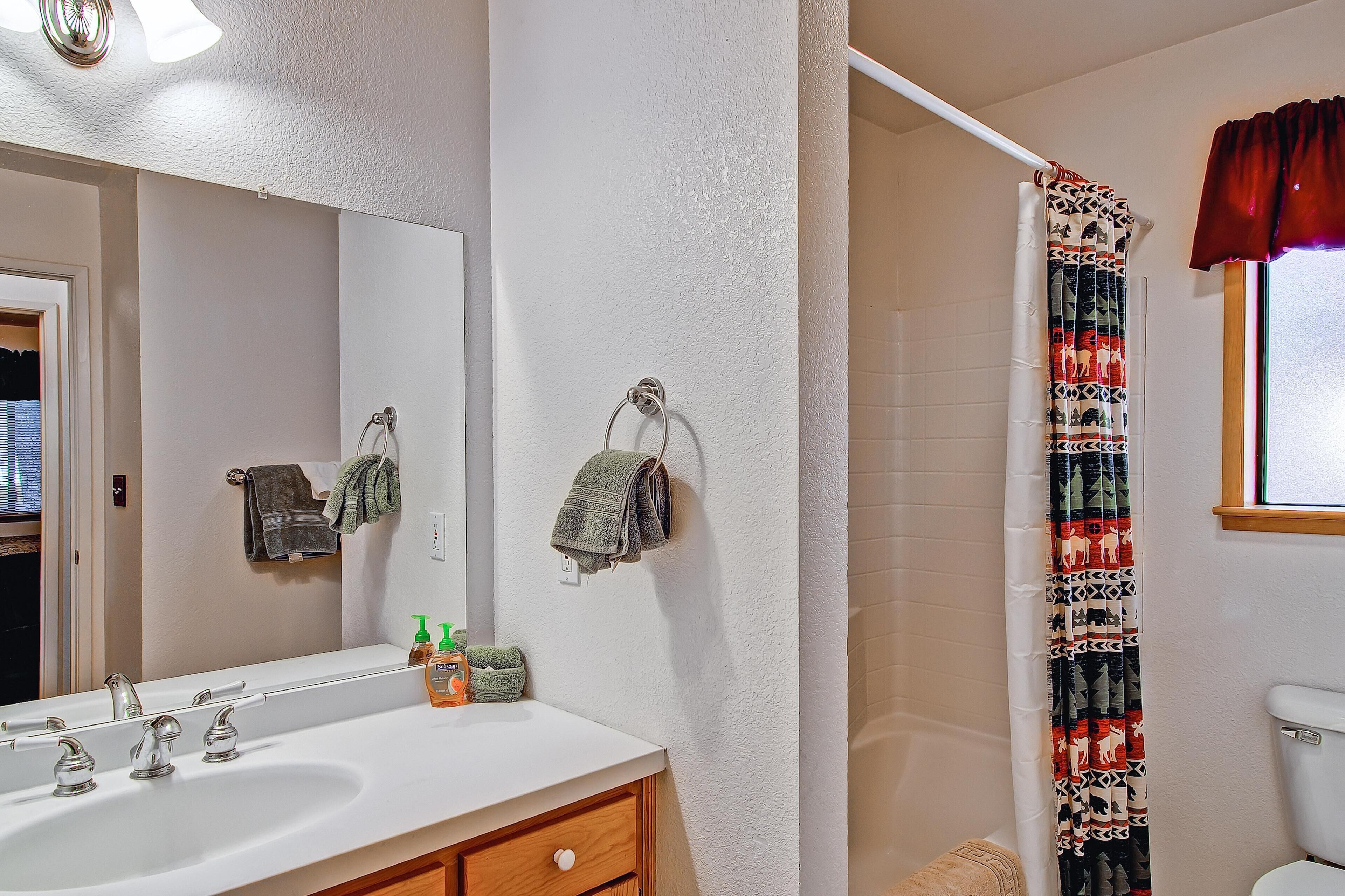 Une salle de bain avec un lavabo blanc, un miroir et un porte-serviettes.