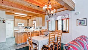 A wooden interior with a dining area, kitchen, and a cozy living space. - Yosemite View (Yosemite National Park)
