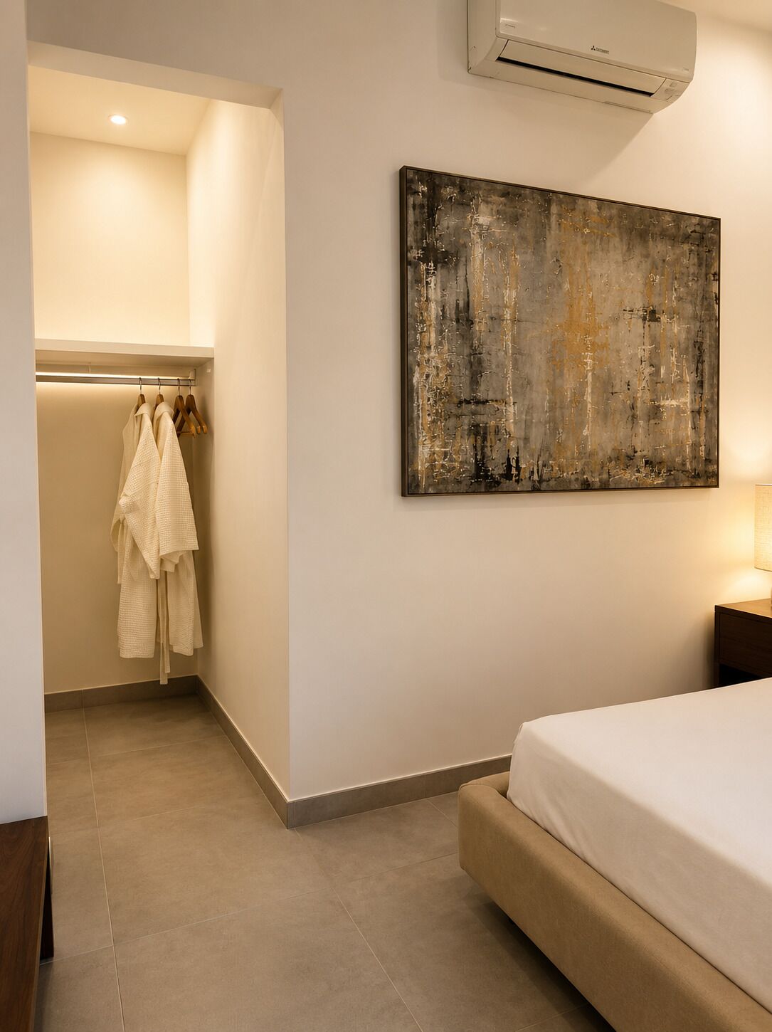 Un dormitorio con una cama, aire acondicionado de pared y un cuadro.