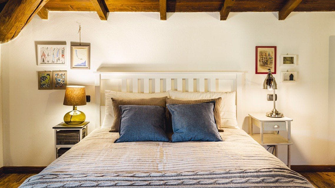 Camera da letto con un letto, due comodini, una lampada e opere d'arte a parete.