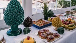 A table with various food items and a decorative tree centerpiece. - Mangia's Himera Resort (Campofelice di Roccella)
