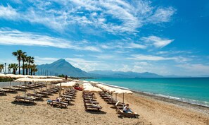 Plage privée, sable noir, chaises longues, parasols