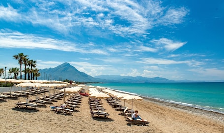 Private beach, black sand, sun loungers, beach umbrellas