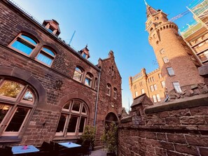 A historic building with a prominent tower and arched windows. - Hotel Hoepfner Burghof (Karlsruhe)