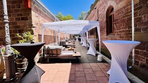 An outdoor patio area with white canopies, tables, and seating arrangements. - Hotel Hoepfner Burghof (Karlsruhe)