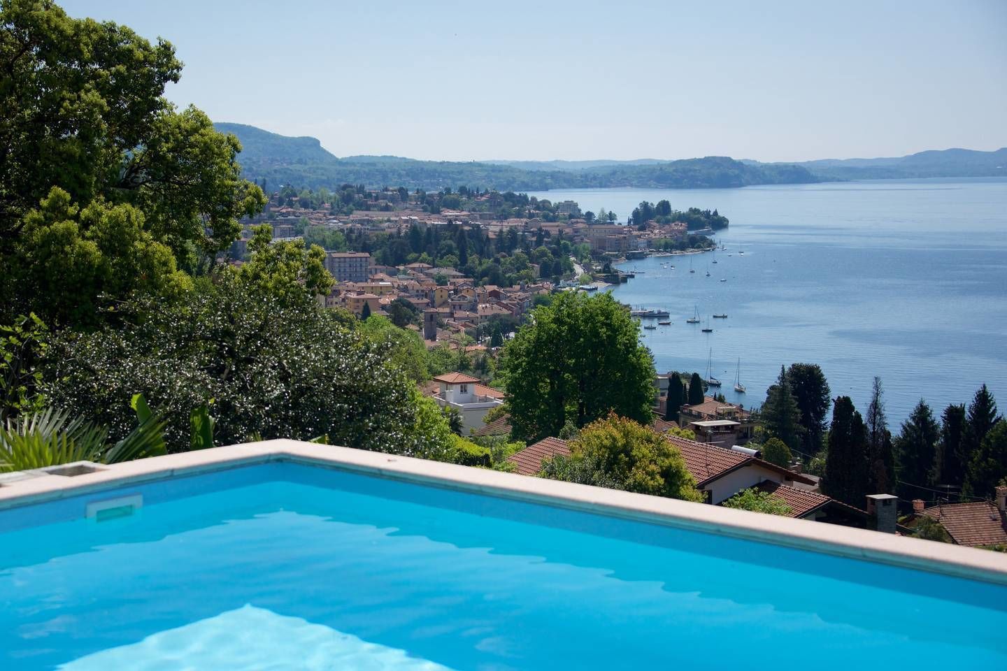 A swimming pool with a view of a coastal town and a body of water.