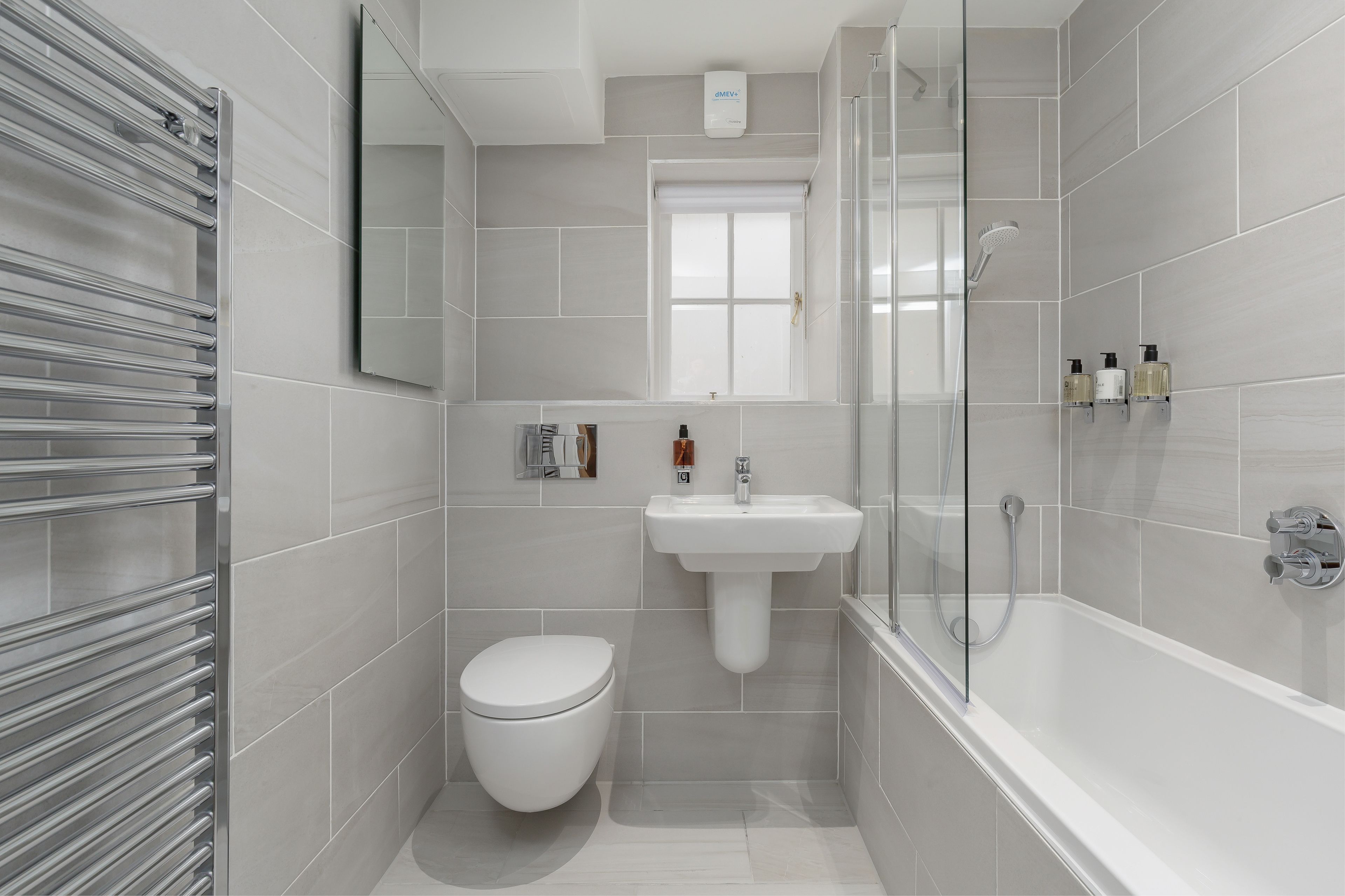A modern bathroom with a toilet, sink, and shower.