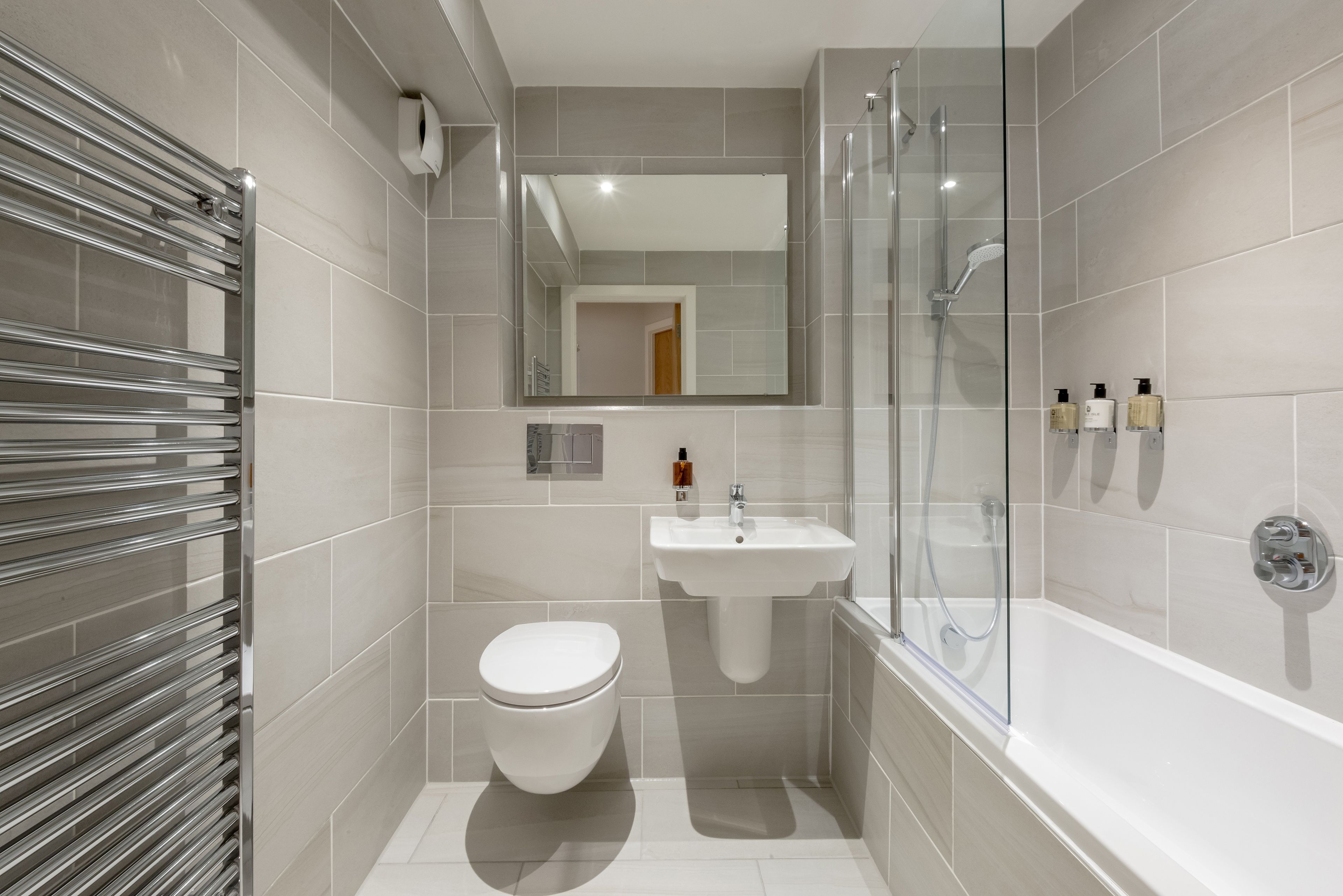 A modern bathroom with a toilet, sink, and shower.