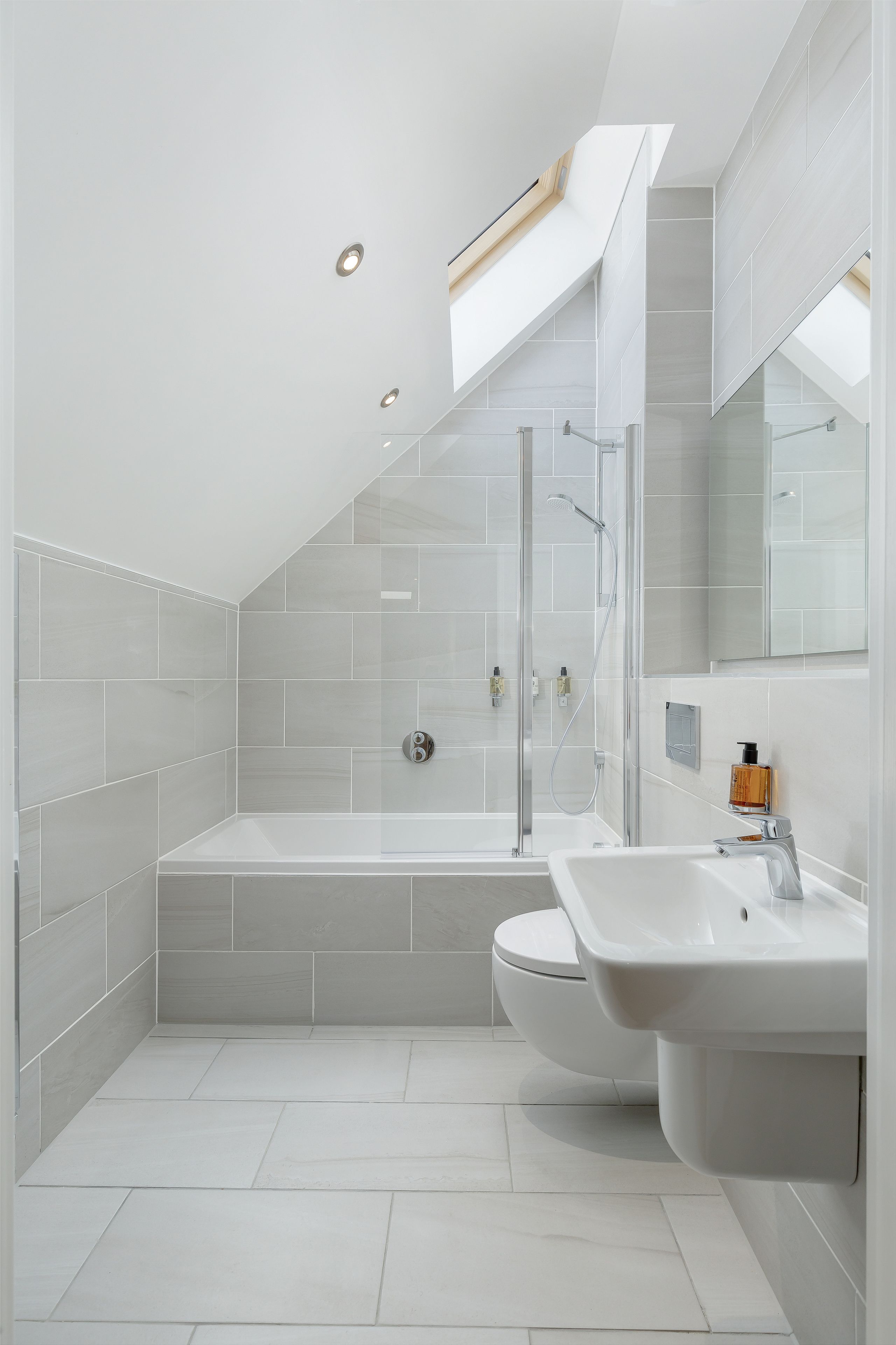 A modern bathroom with a glass-enclosed shower, a freestanding bathtub, and a dual sink vanity.