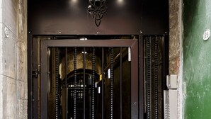 A black metal gate with the address "129 The High Street" and a security camera above it. - Destiny Scotland Royal Mile Residence (Edinburgh)