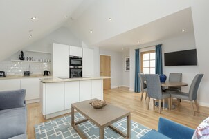 A modern apartment with a kitchen, dining area, and living room.