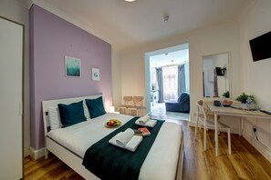 Une chambre comprenant un lit, un bureau et un coin repas.