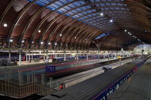 Une gare moderne dotée de plusieurs quais et d’une vaste structure de toit incurvée.