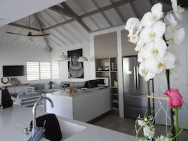 A modern kitchen with a central island, built-in appliances, and a large window.