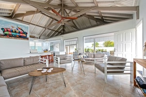 A spacious living area with a high ceiling, a dining area, and a kitchen.