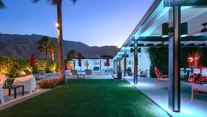 Une terrasse extérieure moderne, dotée d’un espace salon, d’une piscine et offrant une vue sur les montagnes.