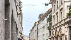 A narrow street lined with historic buildings, featuring balconies and traditional architecture. - AHD Rooms (Milan)