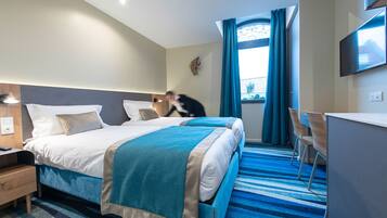 Une chambre d’hôtel avec un lit, un bureau et une chaise.