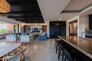 A modern kitchen with dark cabinetry and a granite countertop.