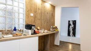 A modern kitchen with a wooden wall, a glass window, and a black and white abstract painting on the wall.