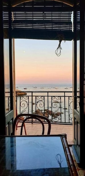 Ein Balkon mit Meerblick, einem Tisch und Stühlen.
