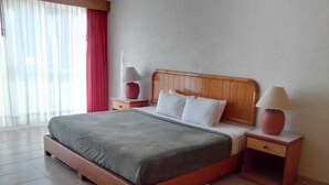 A hotel room with a wooden bed, two bedside tables, a red curtain, and a large window. - La Rinconada (Tequisquiapan)