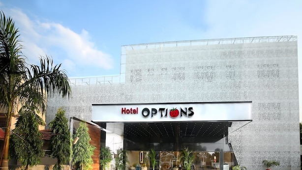 A modern hotel entrance with a large sign reading "Hotel Options." - Hotel  Options Lawns (Shahpura)