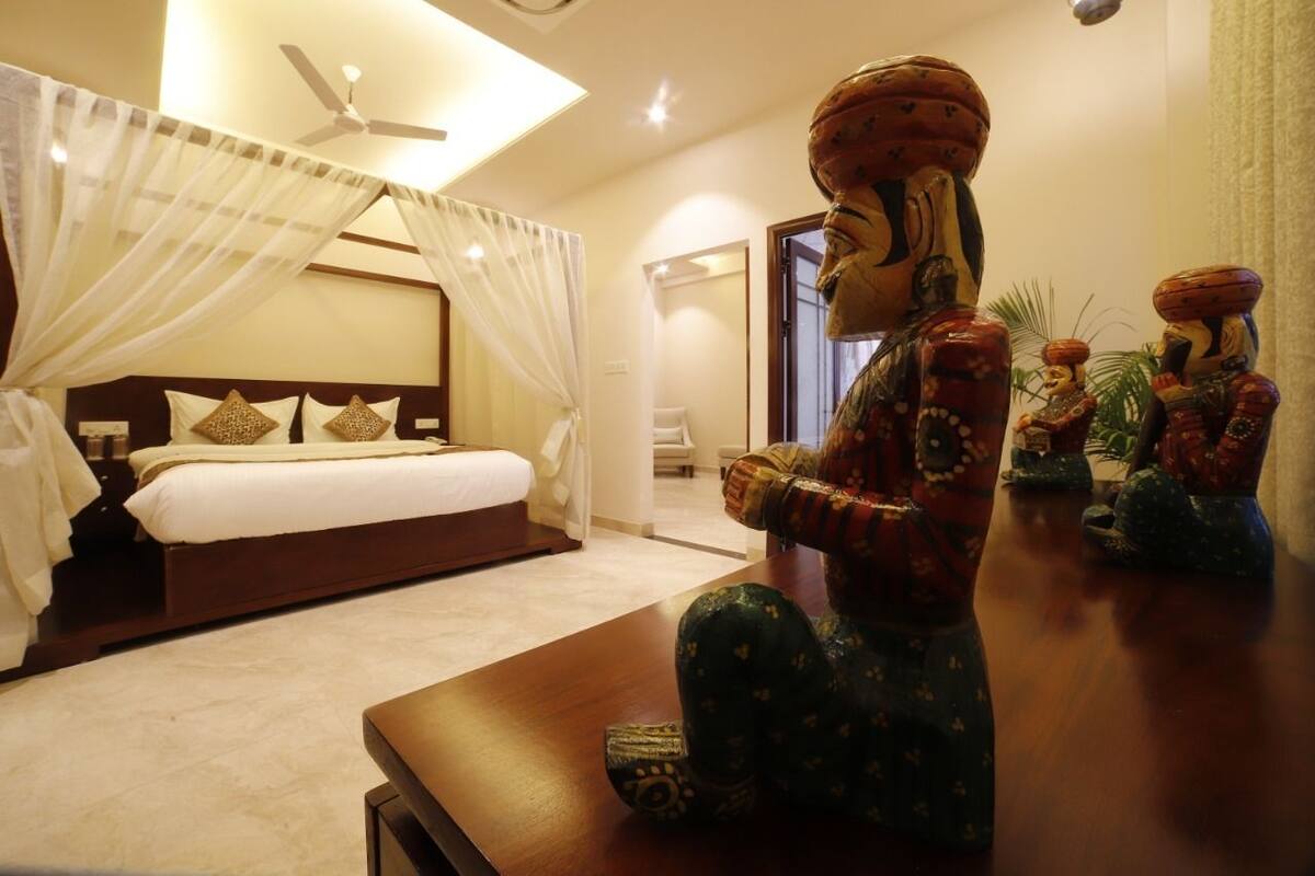 Quarto com cama, ventilador de teto e uma estátua decorativa.