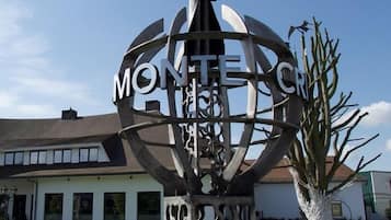 Een metalen sculptuur met de tekst 'MONTE CRISTO' en een figuur van een persoon.