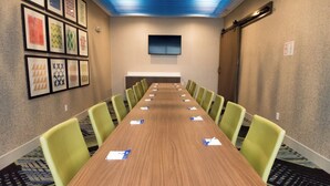 A conference room with a long table, green chairs, and framed artwork on the walls. - Holiday Inn Express & Suites Orland Park - Mokena by IHG (Mokena)