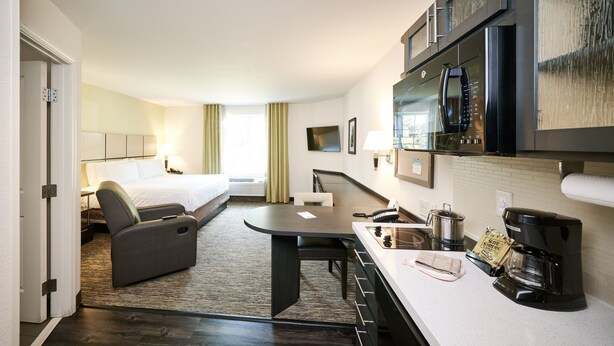 A hotel room with a bed, a desk, a coffee maker, and a microwave. - Candlewood Suites Orlando - Lake Buena Vista by IHG (Orlando)
