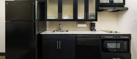 A kitchen with black appliances, a stainless steel sink, and a built-in oven.