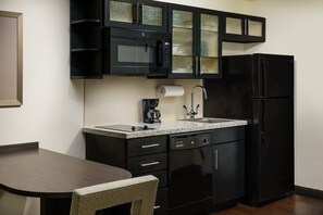A compact kitchen with a microwave, coffee maker, sink, and dishwasher. - Candlewood Suites Orlando - Lake Buena Vista by IHG (Orlando)