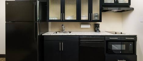 A modern kitchen with black appliances, a stainless steel sink, and a built-in microwave.