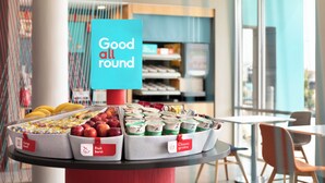 Une présentation de produits alimentaires, dont les étiquettes indiquent « Source d’énergie » et « Explosion de saveurs fruitées », dans un décor moderne avec vue sur l’extérieur par une fenêtre.