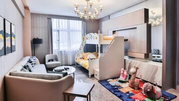 Cozy hotel room with a bunk bed, sofa, and desk area, perfect for families.