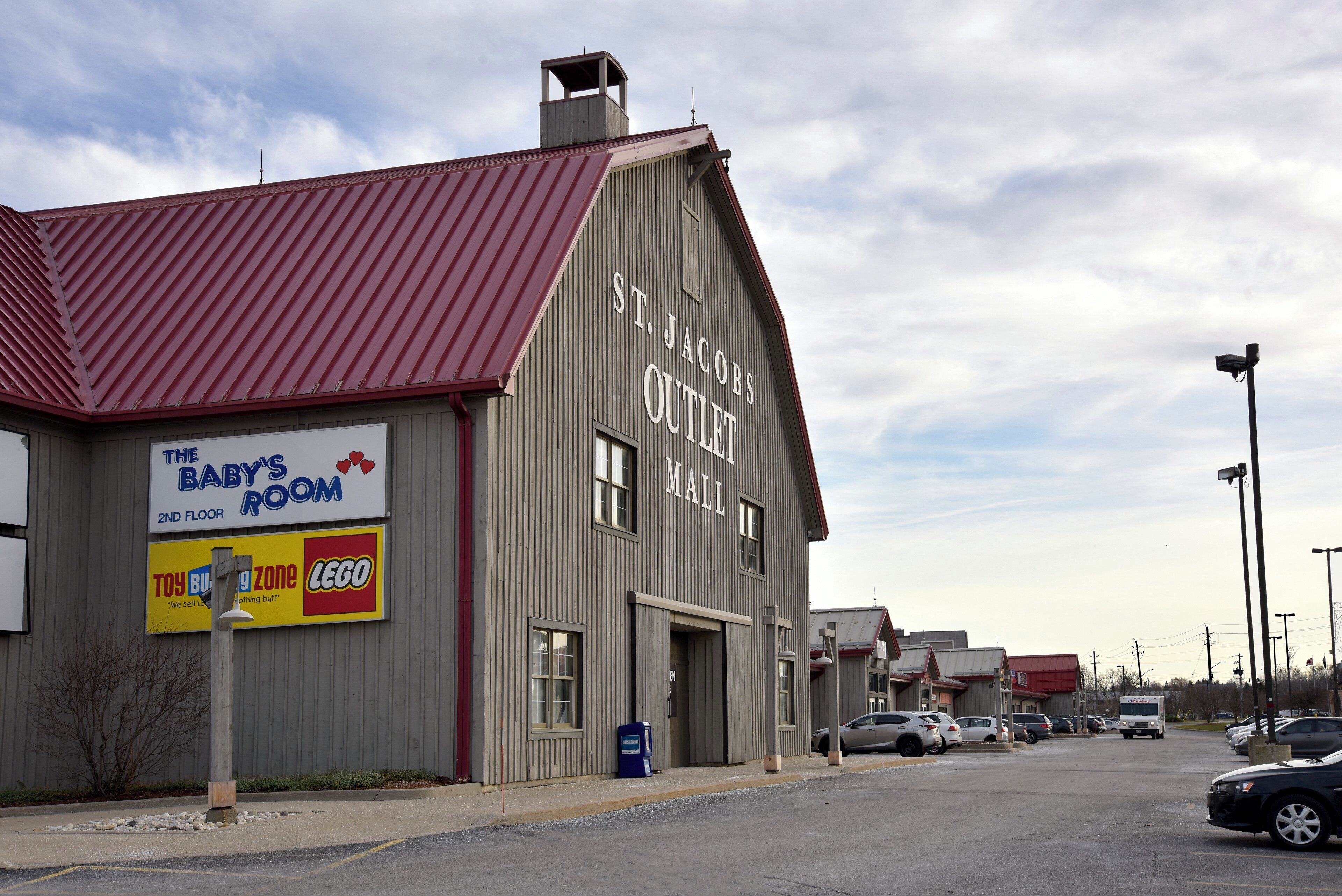 A building with a red roof and a sign for 'St. Jacobs Outlet Mall.'