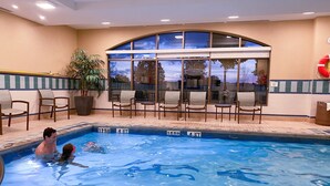 An indoor swimming pool with clear water, surrounded by lounge chairs and a large window. - Staybridge Suites Waterloo - St. Jacobs Area by IHG (Township of Woolwich)