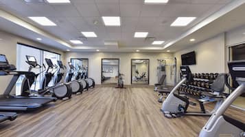 A gym with treadmills, elliptical machines, and weight machines.